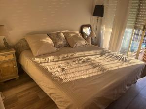 a large bed in a bedroom with a window at Chambre cosy dans T3 in Cannes