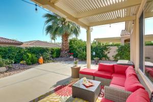 a patio with a red couch under a pergola at Pet-Friendly Indio Home with Hot Tub 55 and Community in Indio
