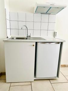 a white kitchen with a sink and a counter at Villa Emilia in Pachis