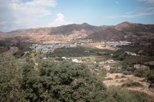a town in the middle of a valley with mountains at El Balcón del Guadalhorce in Alora