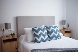 a bedroom with a bed with blue and white pillows at El Balcón del Guadalhorce in Alora