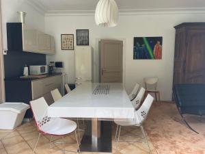 cocina con mesa blanca y sillas en La Feuilleraie, en Tours