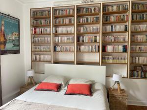 1 dormitorio con 1 cama con estanterías en La Feuilleraie, en Tours 2 fotos más