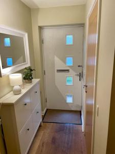 a hallway with a door and a dresser with a mirror at 3 bed house near York centre with off road parking in York +20 photos