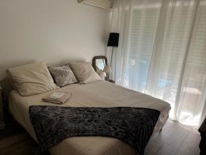 a bedroom with a large bed with a window at Chambre cosy dans T3 in Cannes +8 photos