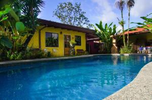 a swimming pool in front of a house at Hotel Arte Natura in Fortuna