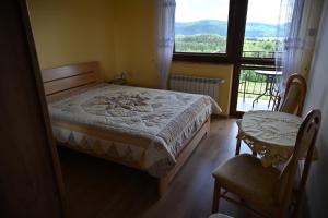 a bedroom with a bed and a window and a table at U Mateusza 607-737-859 in Polańczyk