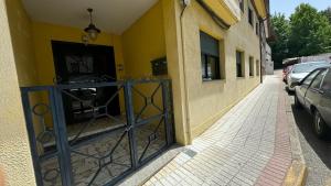 a yellow building with a gate on a street at Camiño da Vila in Redondela