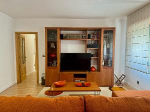 a living room with a couch and a flat screen tv at Camiño da Vila in Redondela