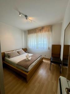 a bedroom with a bed and a chair and a window at Camiño da Vila in Redondela