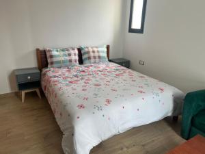 a bedroom with a bed with a floral bedspread at Plage des Nations Prestigia Vue sur mer in Sidi Bouqnadel