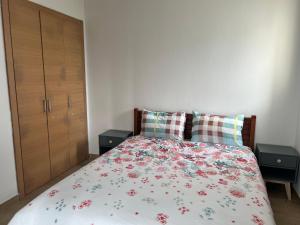 a bedroom with a bed with a floral bedspread at Plage des Nations Prestigia Vue sur mer in Sidi Bouqnadel