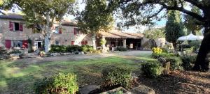 Gite - Domaine Les Peupliers - Lagnes في Lagnes: منزل به ساحة كبيرة أمامه