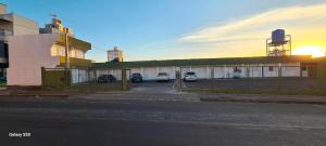 a building with cars parked in a parking lot at Locapart Hospedagens in Chapecó +5 photos
