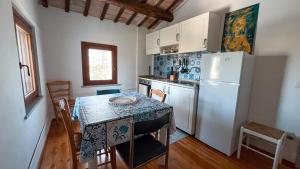 a kitchen with a table and a white refrigerator at Villa Pleiadi in Casa Albonetti