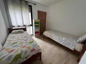 a bedroom with two beds and a window at Plage des Nations Prestigia Vue sur mer in Sidi Bouqnadel