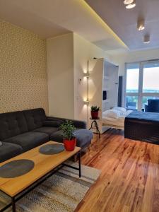 a living room with a couch and a table at Sky View Apartment Szczecin Santocka in Szczecin +23 photos
