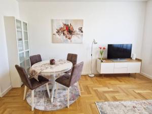 a dining room with a table and chairs and a television at Apartman Diana in Zadar