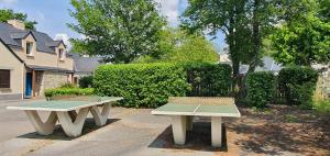 two benches sitting next to each other in a yard at Cottage du Golf en Morbihan in Ploemel +4 photos