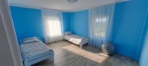ein blaues Zimmer mit 2 Betten und einem Fenster in der Unterkunft Felicita in Sremski Karlovci