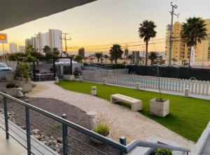a park with a bench and grass and buildings at Departamento Playa La Herradura in Coquimbo