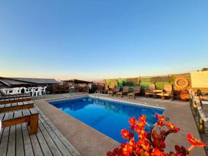 a swimming pool with tables and chairs on a patio at Cabañas DeMAICO in Quintero