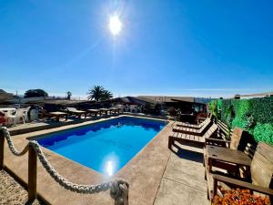 a swimming pool with chairs and a hammock around it at Cabañas DeMAICO in Quintero