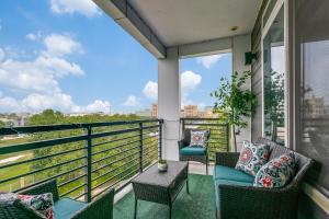 a balcony with chairs and a table and a view at Beautiful Condo on Riverwalk w King Ste free parking pet friendly Centrally Located in San Antonio