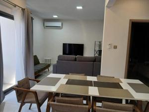 a living room with a table and chairs and a couch at Anuya B1 in Flic-en-Flac