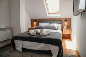 a bedroom with a bed with two towels on it at Pine Lux Zlatibor in Zlatibor