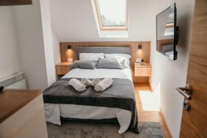 a bedroom with a bed with two towels on it at Pine Lux Zlatibor in Zlatibor