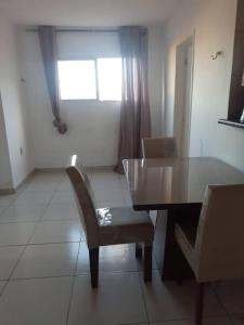 a dining room table with a chair and a window at Apartamento no Centro in Patos