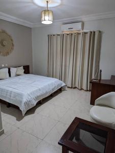 科托努Acropole Hotel的一间卧室配有一张床和一张桌子 更多10张照片