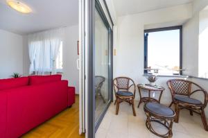 a living room with a red couch and a table at Apartman Diana in Zadar