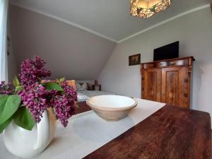 a room with a vase with purple flowers on a table at Ferienwohnung Hofapartment in Milkersdorf