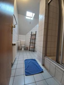 a bathroom with a blue mat on the floor at Ferienwohnung Hofapartment in Milkersdorf