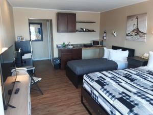 a hotel room with a bed and a kitchen at Berry's Motel in Truro