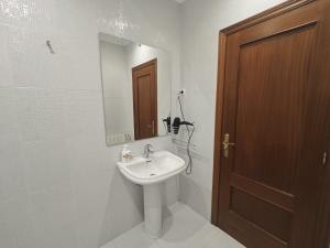 een badkamer met een wastafel en een spiegel bij 2 habitaciones en piso Bilbao in Bilbao