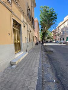an empty city street with a tree and buildings at Little House Galileo in Reggio di Calabria