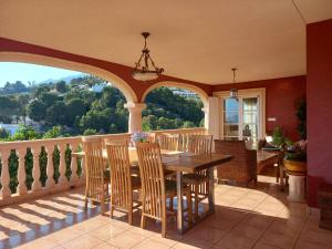una sala da pranzo con tavolo e sedie su un balcone di Villa Anna-Altea ad Altea