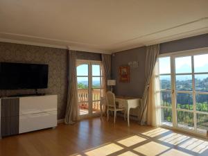 un soggiorno con TV e tavolo con sedia di Villa Anna-Altea ad Altea