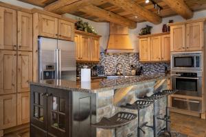 a kitchen with wooden cabinets and a stone counter top at Dreamcatcher at Lakota home in Winter Park