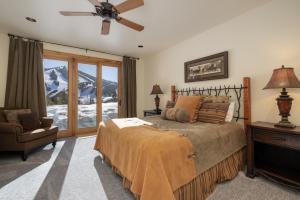 a bedroom with a bed and a chair and a window at Dreamcatcher at Lakota home in Winter Park