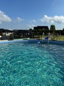 a swimming pool with a slide in the water at Domki Schega in Podamirowo
