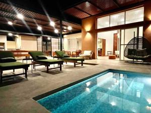 a living room with a swimming pool and some chairs at La Finca Ica in Ica