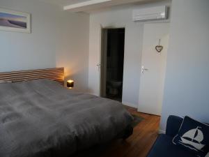une chambre avec un lit et une chaise bleue dans l'établissement Appartement T5 110 m2 climatisé neuf, à 3 minutes des plages, des rues pietonnes Arcachon, à Arcachon