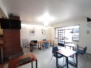 a room with tables and chairs and a fireplace at Casa IAIA in Mexico City