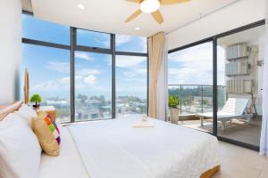 a bedroom with a large bed and a large window at ARIA- VŨNG TÀU - Căn hộ, villa nghỉ dưỡng cao cấp sát bãi biển riêng miễn phí in Vung Tau