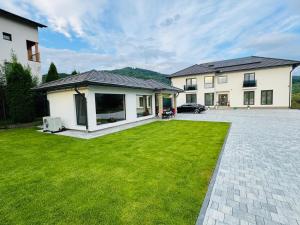 a house with a green lawn in front of it at Vila Diamond Lux&Spa in Sovata