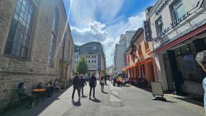 a group of people walking down a city street at Central Charm - Bedroom & Kitchen Apartment near the Main Station Hauptbahnhof in Wuppertal